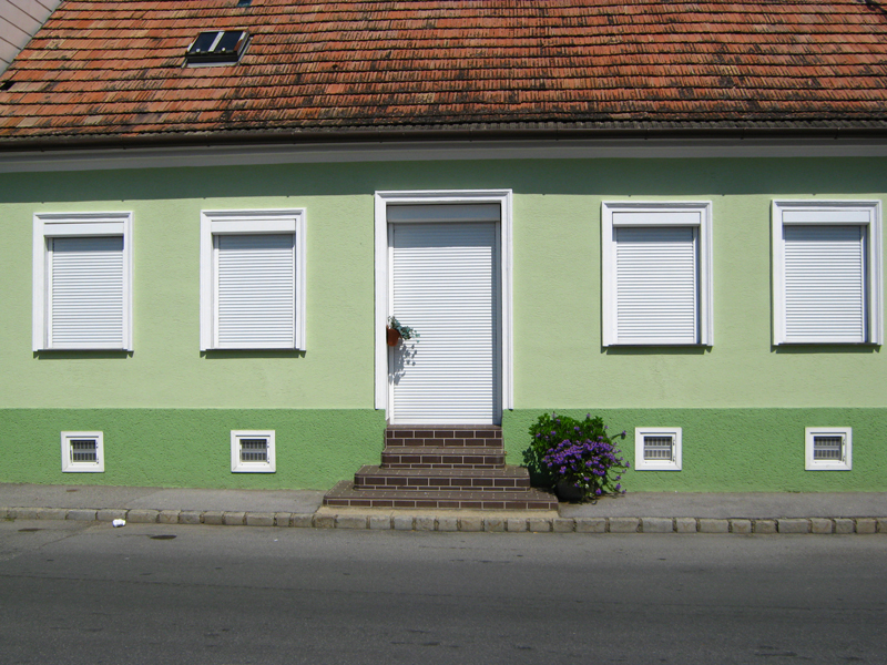 Grünes Familienhaus mit weißen Rollläden Grünes Familienhaus mit weißen Rollläden