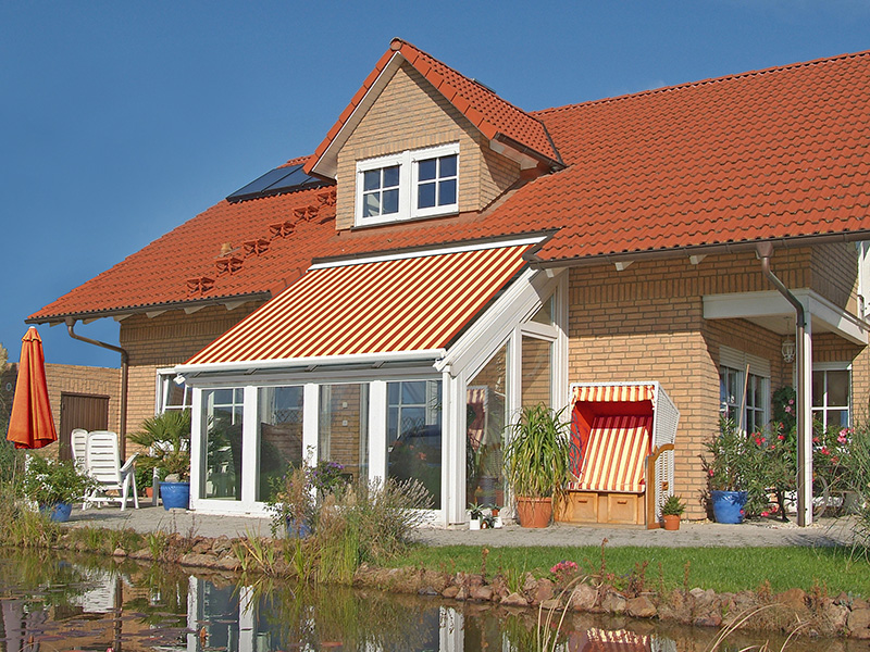 Großes Haus mit rot gelb gestreifter Glasdachmarkise Großes Haus mit rot gelb gestreifter Glasdachmarkise