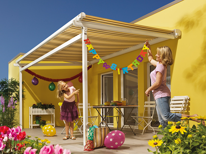 Kind und Mutter dekorieren die Markise Kind und Mutter dekorieren die Markise